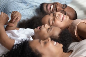 African American family laying on bed- Why join our Maintenance Service Club -Allgeier Air-Louisville-300x200