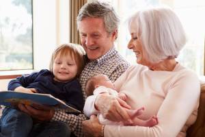 Grandparents reading to kids and baby on couch-Allgeier Air-Louisville KY-300x200jpg