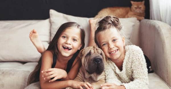 Two young girls smiling on bed with dog- Spring Into Action With 9 Safety Tips-Allgeier Air-Louisville KY-600x315jpg