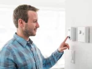 Man setting thermostat-11 Secrets To Reduce Humidity And Avoid AC Repair-Allgeier Air-Louisville KY-400x300jpg 
