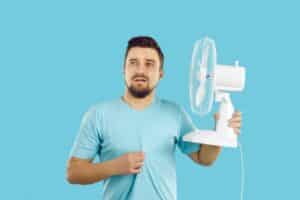Man cooling off with fan-Factors To Consider When Purchasing A New AC Unit-Allgeier Air-Louisville KY-600x400jpg 
